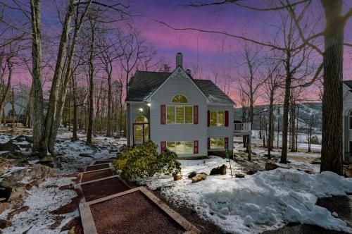 a small white house in the woods with snow at Poconos Paradise Lakeskihikewater Parkkids in Lake Harmony
