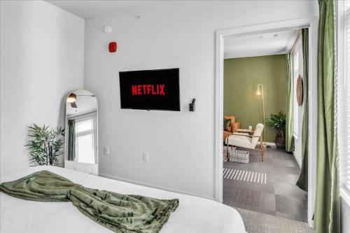a bedroom with a white bed and a living room at Pinnacle Heights 1Bdrm 2nd flr Near Walmart Amp Pool Fitness Center Yoga Studio Dog Spa in Rogers
