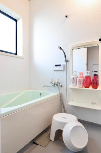 a bathroom with a tub and a toilet and a sink at たび宿Yumiashi in Sendai
