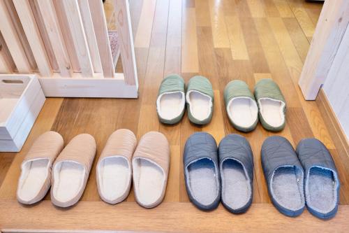 a row of shoes on the floor next to a door at たび宿Yumiashi in Sendai