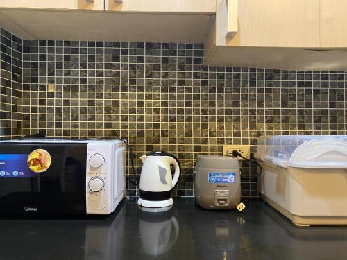 a kitchen counter with a microwave and a coffee maker at Condo Unit at Symphony Towers, Timog, Quezon City in Manila