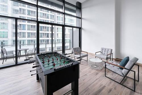 a living room with a foosball table and chairs at Alinea Luxury Condominiums, Shah Alam - Smarthome in Shah Alam