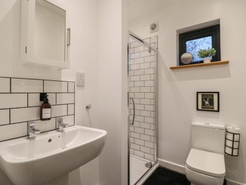 Un baño blanco con lavabo e inodoro. en Hub House, en Hastings