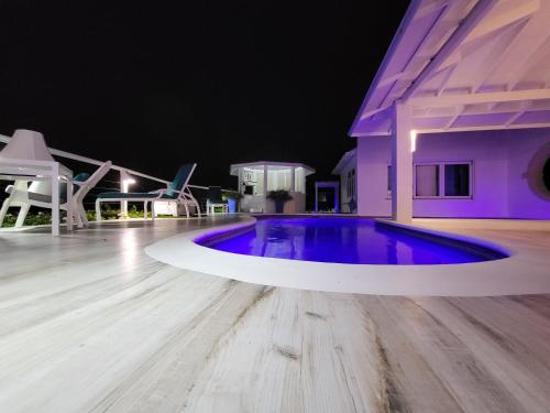 a swimming pool in the middle of a house at night at Unique Villa Retreat Style! Full Sea Views & Pool! villa in Christ Church