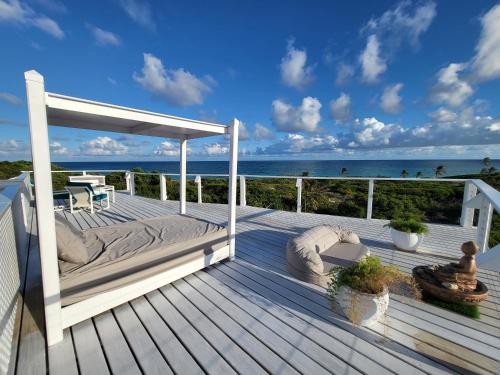 a deck with a bed and a view of the ocean at Unique Villa Retreat Style! Full Sea Views & Pool! villa in Christ Church