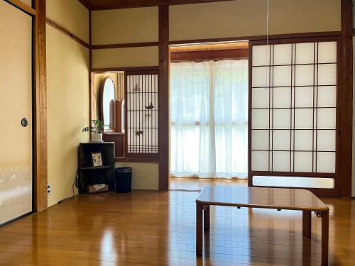 a living room with a table and a window at 畑のおやど in Asago