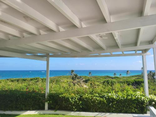 a view of the ocean from the porch of a house at Unique Villa Retreat Style! Full Sea Views & Pool! villa in Christ Church