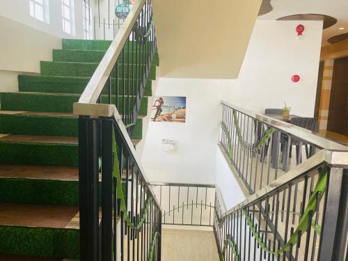 a stairway with green railings in a building at Kayong's Inn in Dumaguete