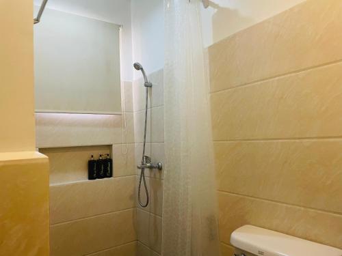 a bathroom with a shower with a shower curtain at Kayong's Inn in Dumaguete