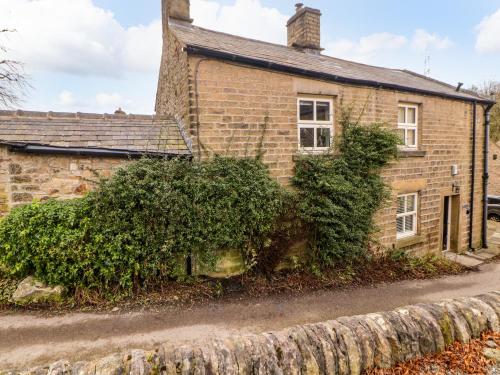 an old brick house with a stone wall in front of it at Homestead in Chapel en le Frith