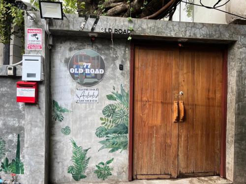 a wooden door with a sign on the side of a building at 77 Old Town in Bangkok