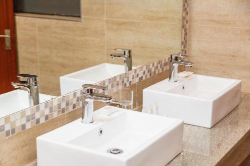 a bathroom with three sinks and a mirror at Blyde Canyon, A Forever Resort in Matibidi