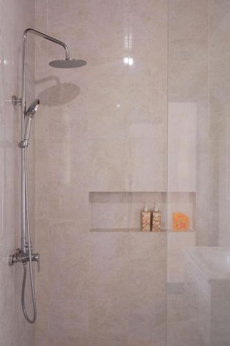 a shower with a glass door with a sink at UCU VILLAGE at ULUWATU JIMBARAN in Jimbaran
