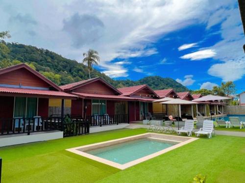 une maison avec une piscine et de l'herbe verte dans l'établissement Lanta For Rest Boutique, à Ko Lanta