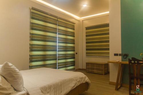 a bedroom with a bed and a large window at GQ Sands in Tangalan