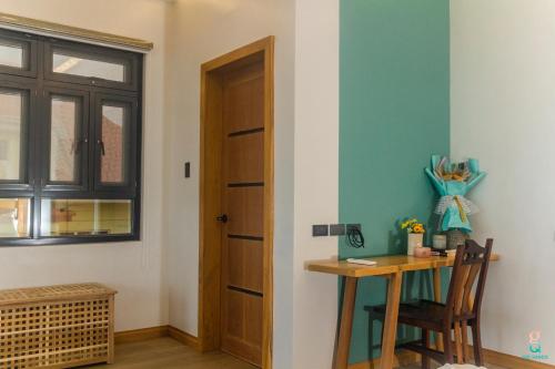 a room with a table and a door and a desk at GQ Sands in Tangalan