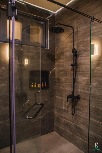 a shower with a glass door in a bathroom at GQ Sands in Tangalan