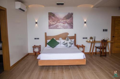 a bedroom with a bed and two chairs in it at GQ Sands in Tangalan