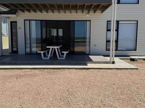a patio with a picnic table in front of a house at Zion on Yorkes in Edithburgh