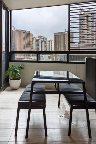 a table and bench in a room with a large window at Free Parking 2 Bedroom at Haymarket Chinatown Near Light Rail in Sydney