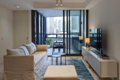 a living room with a couch and a large window at Free Parking 2 Bedroom at Haymarket Chinatown Near Light Rail in Sydney