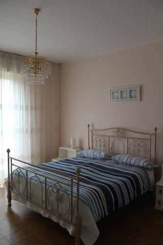 a bedroom with a large bed with a chandelier at B&B Da Roby in Corinaldo