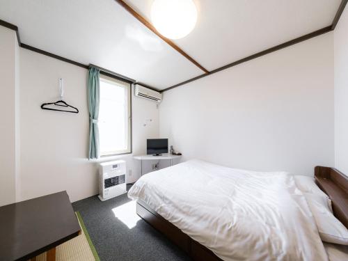 a bedroom with a bed and a window at Tabist Diversity Hotel Sin Tokiwa Asahikawa in Asahikawa