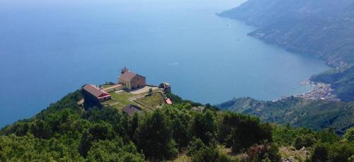 a house on top of a hill next to a body of water at Casa Ferrigno in Maiori