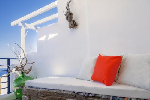 a white couch with a red pillow on it at Castria studios in Kionia