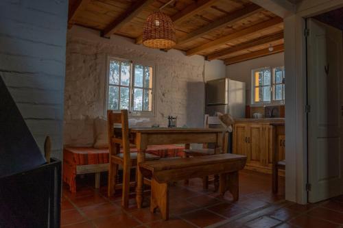una cucina con un tavolo di legno e una sala da pranzo di Casa Cálida Colonia a Colonia del Sacramento