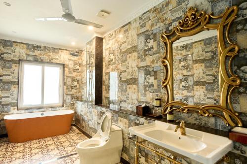 a bathroom with a tub and a toilet and a sink at Mayfair Manor Alibag in Alibaug