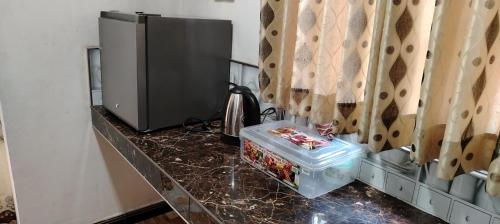 InamaluwaにあるMG Homesの電子レンジと冷蔵庫を備えたキッチンカウンター