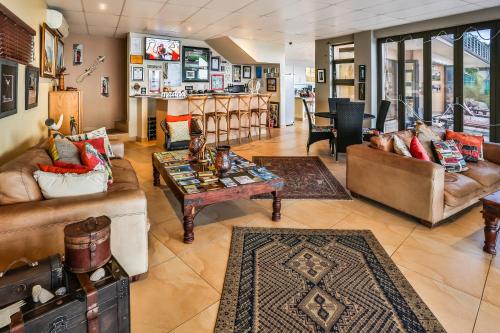 a living room with couches and a table at Zimbali View Eco Guesthouse in Ballito