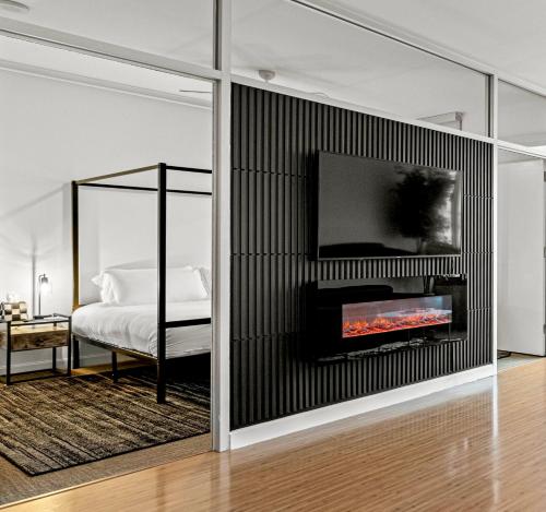 a bedroom with a fireplace and a tv on a wall at Modern Downtown Dallas City View High-Rise, Free Parking, Pool, Gym in Dallas