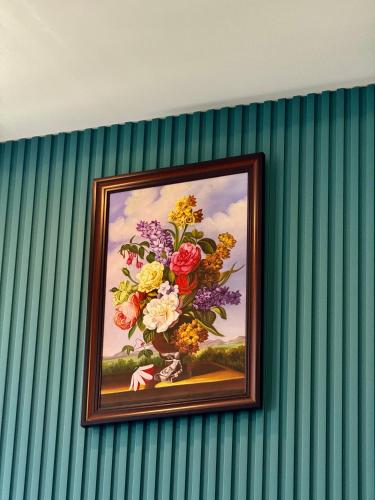 a painting of a vase of flowers on a wall at Keang You Boutique Hotel in Phnom Penh