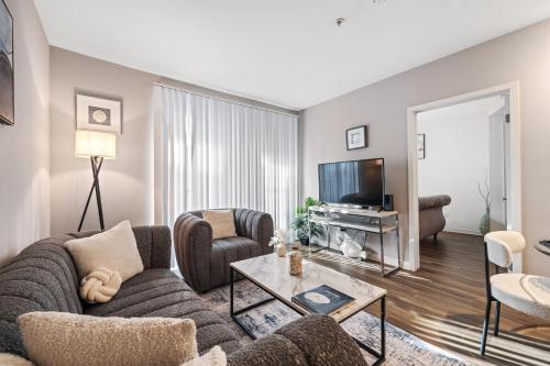 a living room with a couch and a tv at Location Walk to the beach Chic Condo! in Los Angeles
