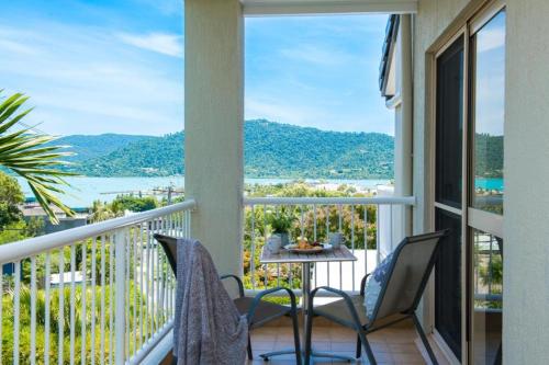 a balcony with a table and chairs and a view of the water at Beach House on Begley- Airlie Beach Central in Airlie Beach
