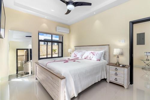 a bedroom with a large bed and a ceiling fan at Great Escape Villa - Ocho Rios in Ocho Rios