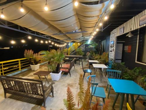 ein Restaurant mit Tischen, Bänken und Topfpflanzen in der Unterkunft Himori homestay & coffee in Ấp Kim Thạch