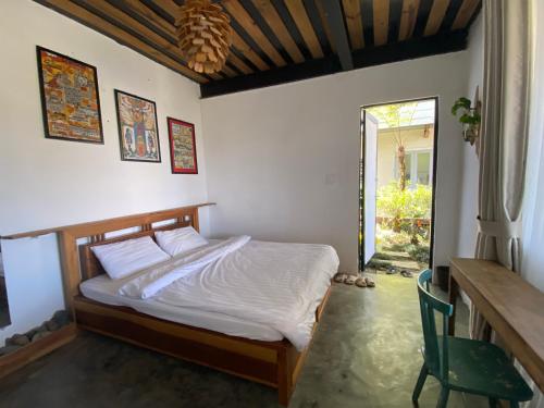 ein Schlafzimmer mit einem Bett und einem Tisch und einem Fenster in der Unterkunft Himori homestay & coffee in Ấp Kim Thạch