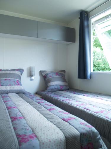 deux lits dans une chambre avec une fenêtre dans l'établissement CAMPING PANORAMIQUE du VERDON, à Castellane