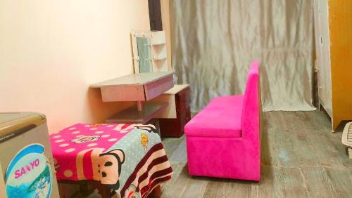 a room with a pink chair and a desk at Happy Farm Homestay in Ấp Long Ðại