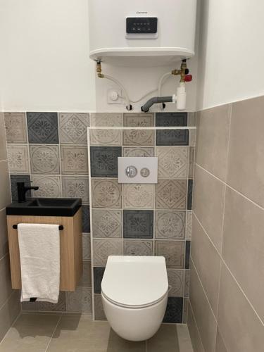 une salle de bain avec des toilettes blanches et un lavabo dans l'établissement O Portes des HALLES, à Cavaillon