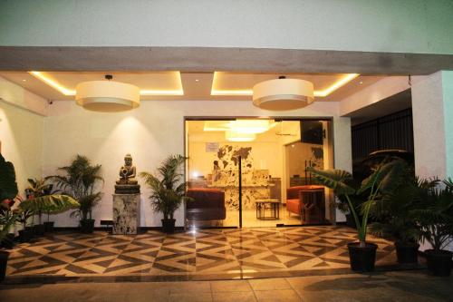 a lobby with potted plants in a building at Hotel Comfort Inn in Pune