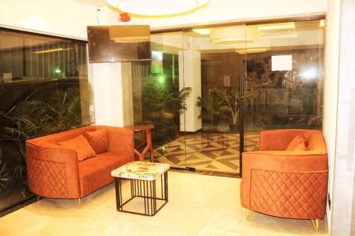 two orange chairs and a table in a lobby at Hotel Comfort Inn in Pune
