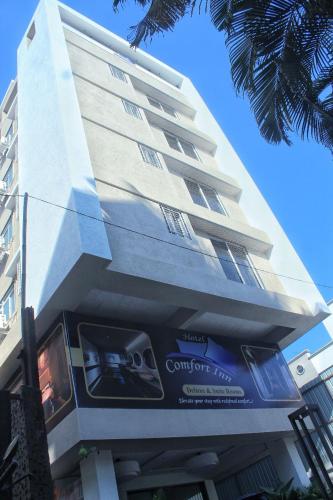 a tall building with a sign in front of it at Hotel Comfort Inn in Pune