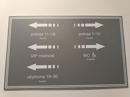 a sign with arrows pointing in different directions at Hotel a ubytovna Zimní stadion Slaný in Slaný