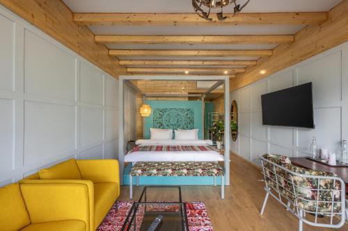 a bedroom with a bed and a flat screen tv at Echor Himalayan Heights Luxe Manali in Manāli