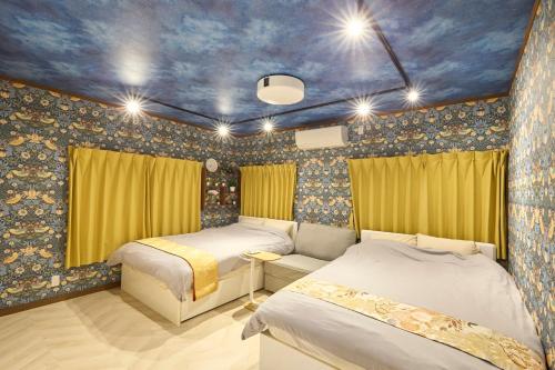 a bedroom with two beds and a blue ceiling at Numazu Sparkle in Numazu