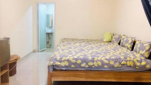 a bedroom with a bed with a yellow pillow at Mây Villa in Da Lat